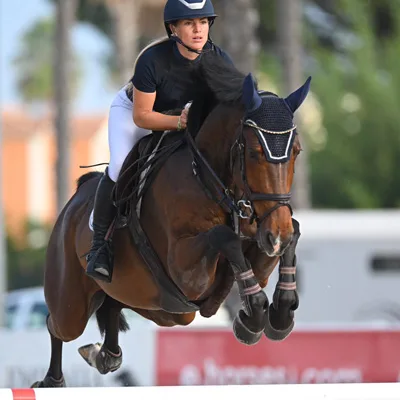 Anna-Maria Kuhlmann springt mit einem braunen Pferd über ein Hindernis