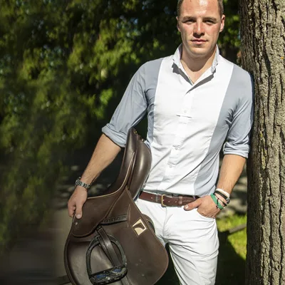 Maxi Lill an einen Baum gelehnt mit einem Childéric Springsattel im Arm